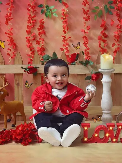 Spreading the love with a Valentine's themed sitter session. This little boy in his red jacket looks so handsome against the romantic red backdrop with woodland creatures.