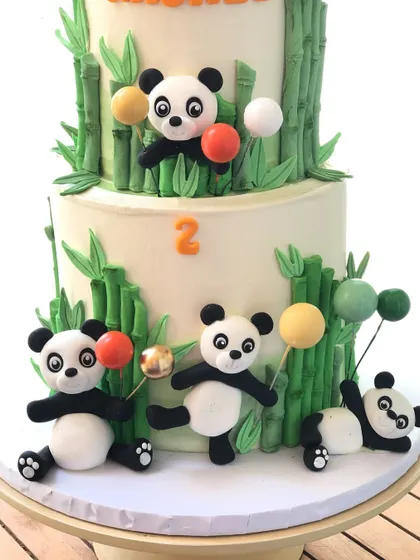 A close-up of the cute fondant pandas on the two-tiered bamboo cake.