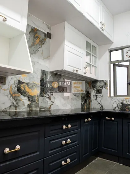 A stunning kitchen from our Kolkata project, featuring deep navy blue cabinets with elegant gold-accented handles. The marble-patterned backsplash adds a touch of drama and luxury.