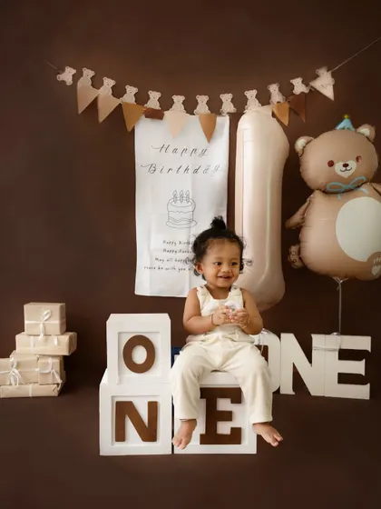 Sitting proudly on the "ONE" blocks. These props are a popular choice for first birthday shoots and help mark this special milestone.