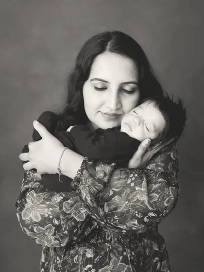 A mother cradling her sleeping baby. This classic black and white portrait is timeless and full of grace.