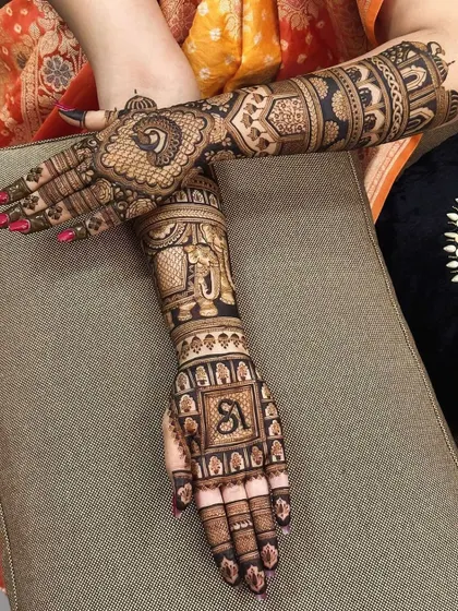 This design combines two of my favorite royal motifs: a graceful peacock on the back of the hand and a strong elephant on the forearm, along with the bride's initial.