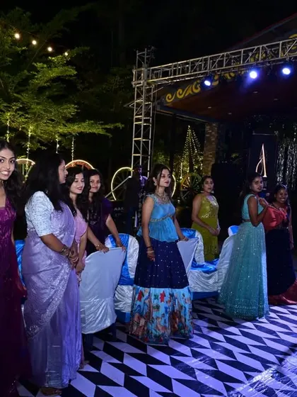 The host getting the ladies together for a performance. The blue outfit stands out beautifully in the evening lights.