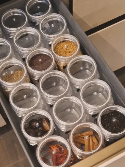 A drawer full of whole spices, each in its own clear-lidded jar. This system makes it easy to see what you have and grab what you need.