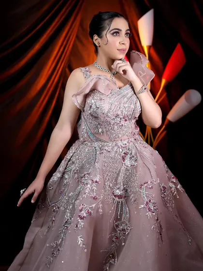 A portrait of the model, showcasing the intricate details of the gown and the sophisticated makeup look.