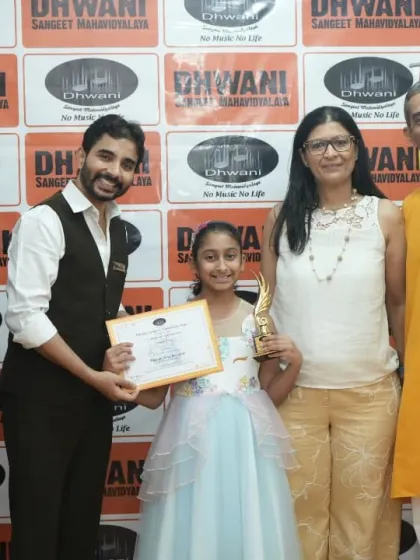 A student with her family and teachers, celebrating her success at the annual awards.