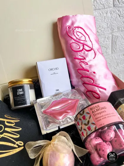 Another angle of our curated bridal hamper, showing the arrangement of the embroidered robe, scented candle, and gourmet snacks.