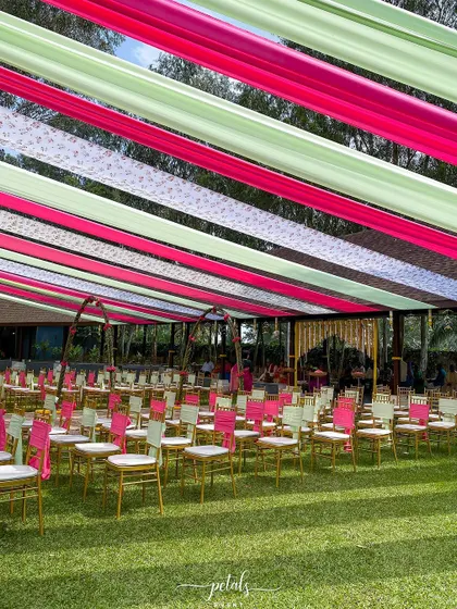 The guest seating for this colorful wedding is arranged beautifully on the lush green lawn.