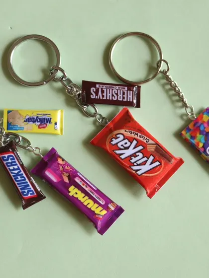 A collection of various miniature chocolate bar keychains, including Snickers, Munch, and Hershey's.