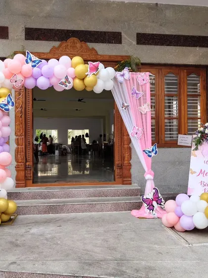 A beautiful balloon arch at the entrance of a butterfly-themed party.