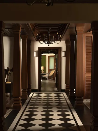 The main corridor, designed as a grand procession space. The symmetry of the pillars and the graphic checkerboard floor create a powerful axial view that draws you into the heart of the home.