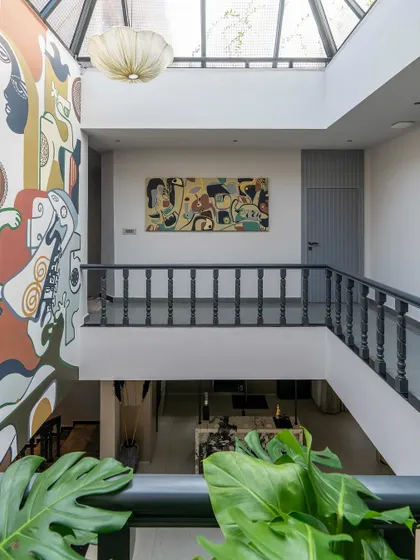 A view from the balcony, showcasing the scale of the double-height mural and its integration with the home's interior design.