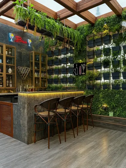 We can integrate a fully functional and stylish bar into your outdoor space. This terrace bar features a vertical garden wall, hanging ferns from the pergola, and warm under-counter lighting, creating a vibrant and inviting atmosphere for hosting guests.