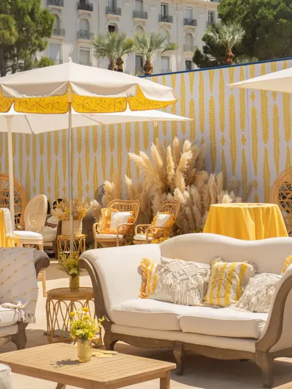 The lounge area was designed for comfort and style, with elegant white sofas, macrame cushions, and pops of yellow, creating a perfect space for guests to relax.
