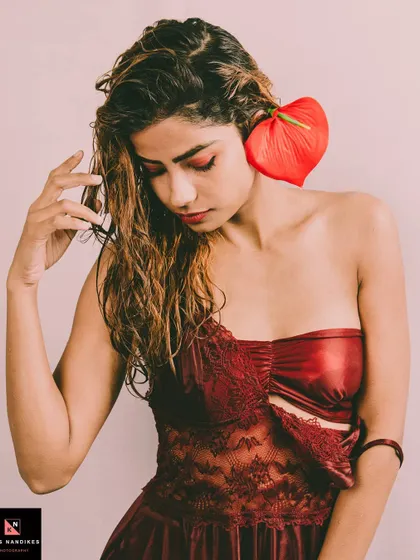 An evocative portrait from the 'Depression' series, where the model holds a red anthurium flower. The image uses color and symbolism to explore complex emotions and mental health awareness.
