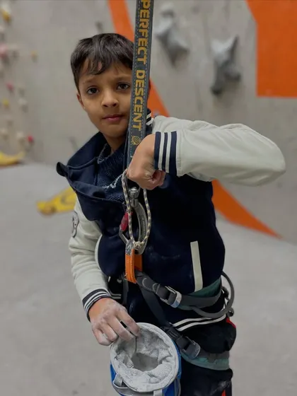 A young climber, chalk bag in hand, is ready for his next adventure. We welcome climbers of all ages to start their journey with us.