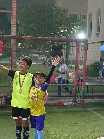 Two champions holding up their trophy and medals. Our parties are designed to build confidence and a love for the game.