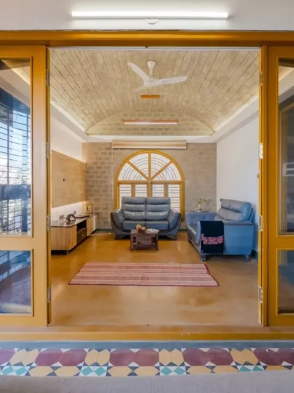 A view from the semi-open lounge into the family room, showcasing the vaulted brick ceiling and the seamless connection between spaces.