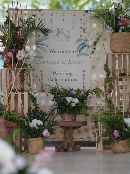 Your story begins the moment your guests arrive. We design personalized welcome signage and entryways, like this rustic-chic setup with wooden crates, fresh greenery, and a custom welcome board, to create a warm and inviting first impression.