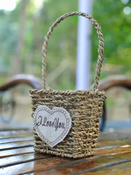 A charming small woven basket with an "I love you" heart, making it a perfect container for a thoughtful plant gift.
