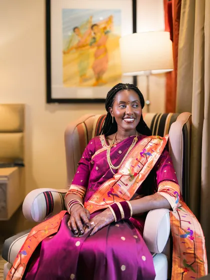 A happy, relaxed portrait of a bride in a beautiful magenta and orange saree.