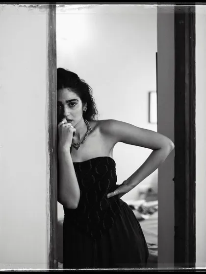 A black and white portrait of Kavya Trehan peeking from behind a doorway. It’s a simple composition that feels intimate and a little mysterious.