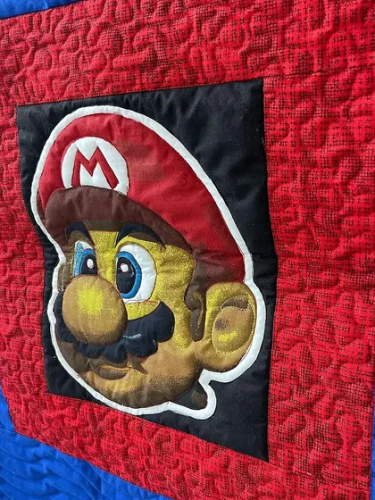 A detailed close-up of the Super Mario appliqué, showing the precise stitching.