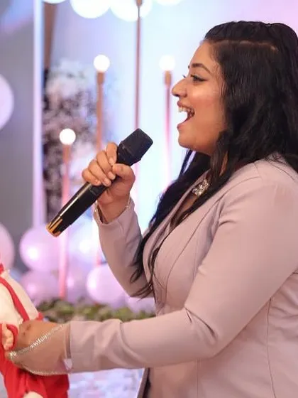 A party host leading a fun game at a baby shower, ensuring all the guests are entertained.