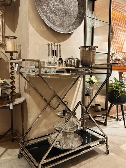 This magnificent bar trolley with a geometric silver frame is a true showstopper. It's a piece of functional art for the host with a modern aesthetic.