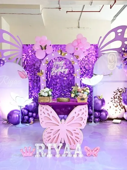 A vibrant purple butterfly theme with a sequin backdrop, showing how the same theme can be adapted to different color schemes.