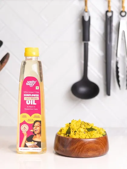 A clean and bright product shot of sunflower oil next to a bowl of poha, the dish it helps create. This contextualizes the product and gives the customer a usage idea.