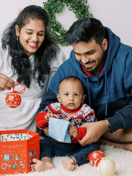 A family opening presents by the tree. A candid moment of holiday fun.