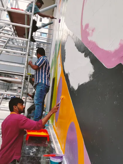 A work-in-progress shot of a huge mural for a sports arena in a Hyderabad tech office. It takes a team of dedicated artists on scaffolding to tackle a wall this big.