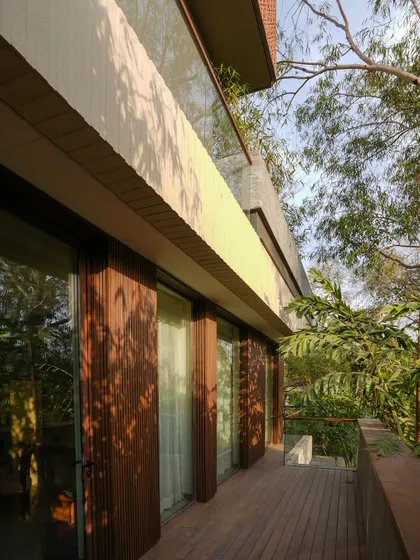 At The Lantern House, stacked terraces and balconies extend the living spaces vertically, inviting greenery and air into every level. The use of natural wood decking and glass railings ensures an uninterrupted connection with the surrounding trees.