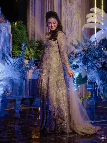 The bride looking radiant in her shimmering gown, surrounded by cool blue lighting and disco-themed decor.