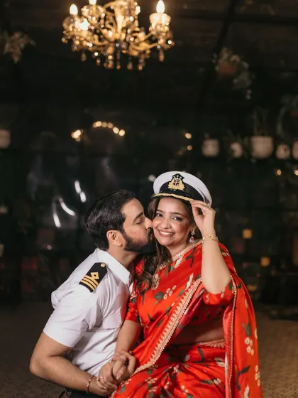 A playful and affectionate kiss on the cheek, incorporating the captain's hat as a fun prop.