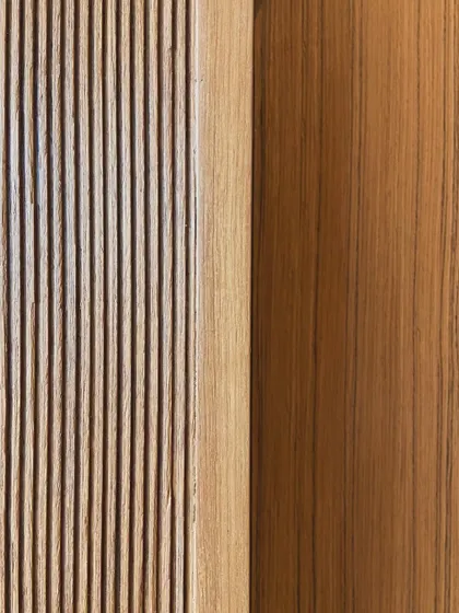 A detail showing the transition from a fluted wood surface to a smooth plane. This careful handling of junctions and transitions is critical to achieving a polished and resolved interior.