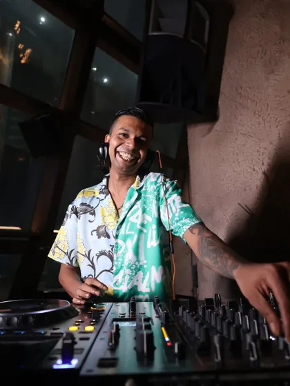 A smile is the best way to connect with the crowd. A candid shot of me enjoying the moment behind the decks in a colorful floral shirt.