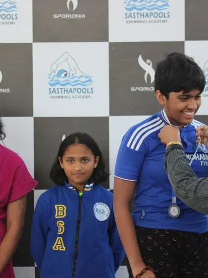 A close-up of a young swimmer receiving her medal, a moment of pride and accomplishment.