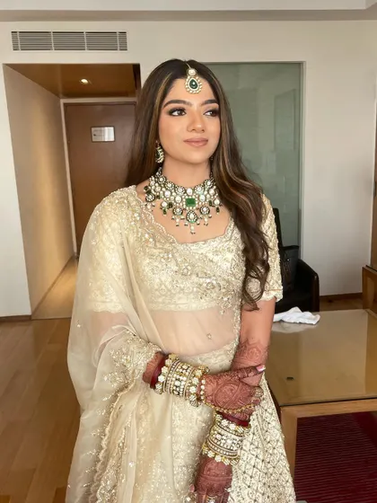 A chic and modern bridal look for Mahek. The makeup is kept neutral and warm, perfectly complementing her Anushree Reddy design and green jewelry.
