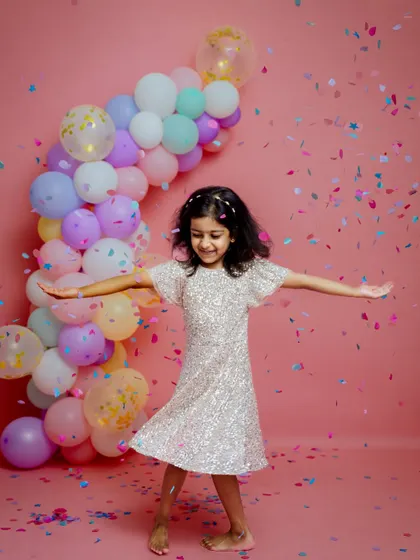 Twirling with joy during a fifth birthday confetti session. These action shots perfectly capture the carefree spirit of being a kid.