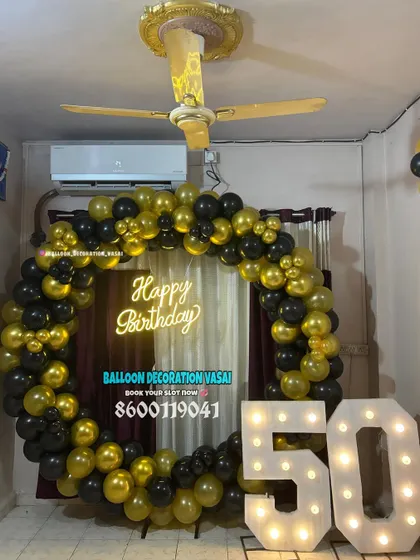 A bold black and gold balloon ring for a 50th birthday. This setup is perfect for making a statement in any home or hall.