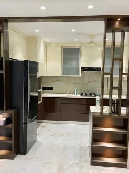 A view from the dining area into the kitchen, framed by a custom-built wooden partition with display shelves. This feature creates an open yet distinct separation between the two spaces.