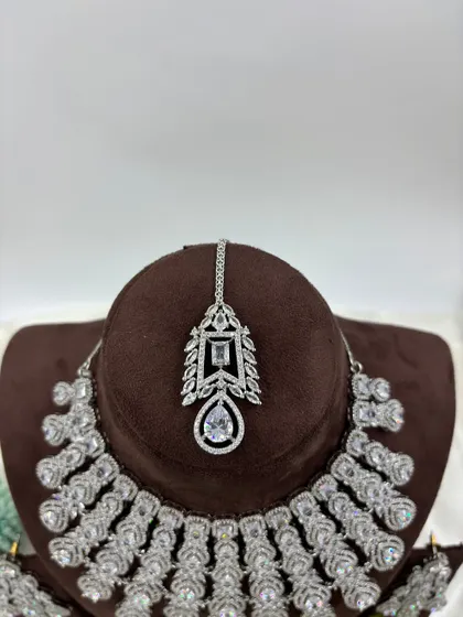 A magnificent, full-coverage AD necklace set designed for grand events. The intricate web of American Diamonds creates a dazzling effect, perfect for bridal and reception wear.