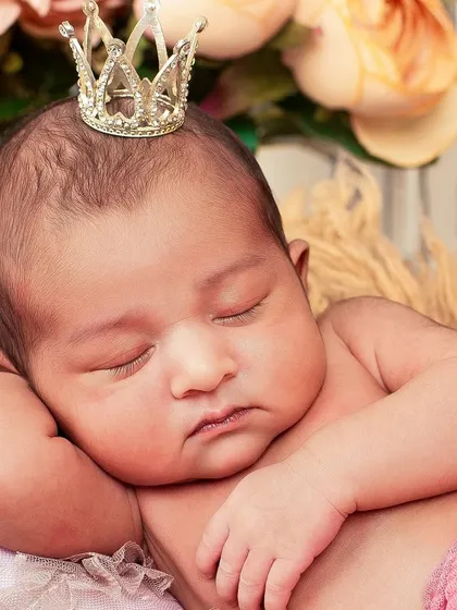 A close-up of a sleeping newborn princess, complete with a tiny crown. These detailed shots capture the delicate features you'll want to remember forever.