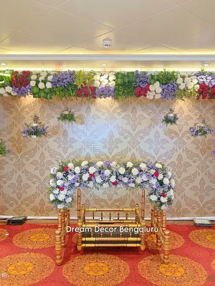 Another angle of this colorful cradle ceremony decor. The full floral frame and decorated cradle create a grand and festive look, perfect for celebrating a new life.