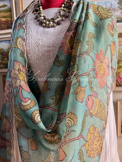 A detailed view of the draped dupatta, showcasing the artistry of the hand-painted Srikalahasti motifs and the fine craftsmanship of the scalloped border.