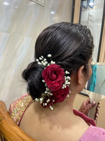 The client admiring her beautiful floral hairstyle in the mirror.