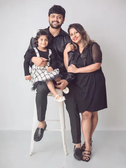 A classic standing family portrait with their daughter seated on a stool. This pose is great for showing the family together in a clean and elegant way.