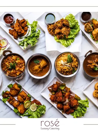 A stunning top-down view of a multi-course Indian meal we catered. It showcases the variety we offer, from appetizers like pakoras and samosas to rich curries and biryani.